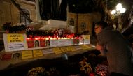 A tourist looks at a makeshift memorial to assassinated anti-corruption journalist Daphne Caruana Galizia after an anti-corruption protest against the government of Prime Minister Joseph Muscat in Valletta, Malta, November 16, 2019. REUTERS/Darrin Zammit 