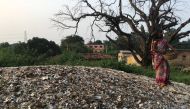A woman stands atop a pile of mica in Giridih, India, on October 16, 2019. Thomson Reuters Foundation/Roli Srivastava 