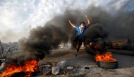A protester jumps between burning tires during ongoing anti-government protests in Basra, Iraq November 24, 2019. Reuters/Essam al-Sudani