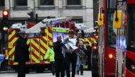 Police assist an injured man near London Bridge in London, on November 29, 2019 after reports of shots being fired on London Bridge. AFP / DANIEL SORABJI