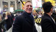 Actor Daniel Craig reacts next to actor Rami Malek during a promotional appearance on TV in Times Square for the new James Bond movie 