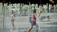 Children cool off in a fountain in Albi, southern France on August 5, 2018, in a European heatwave. AFP / Remy Gabalda