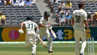 Australia's David Warner (L) and Joe Burns (C) make runs as New Zealand bowler Tim Southee (R) looks on, on day one of the first Test cricket match between Australia and New Zealand at the Perth Stadium in Perth on December 12, 2019. -- / AFP / PETER PARK