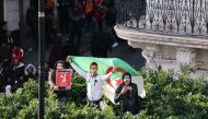 Demonstrators shout slogans during a protest to reject the presidential election in Algiers, Algeria December 12, 2019. The sign reads: 