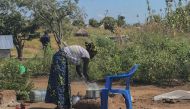 Emily Bronte's wife cooks over a fire at the family's home in the Bidi Bidi refugee settlement. Yumbe district, Uganda. Picture taken Nov. 29, 2019. Thomson Reuters Foundation/Claire Cozens