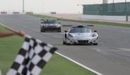 Ibrahim Al Abdulgahni (right) taking  the chequered flag to win Race 2 of the opening round of the Qatar Touring Car Championship at Losail International Circuit.