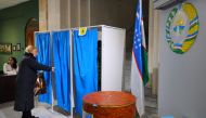 A woman goes in a polling booth before voting at a polling station in Tashkent on December 22, 2019. AFP / Yuri KORSUNTSEV