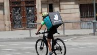 A biker wearing a Deliveroo backpack drives in the central Barcelona, Spain, July 23, 2019. Reuters/Albert Gea