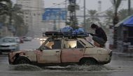 A car drives through a flooded road following heavy rain in Gaza City on December 27, 2019. AFP / Mohammed Abed 