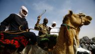 File photo: Sudanese men ride camels as they gather to attend a speech by then Sudanese president during his visit to El Daein in Eastern Darfur on April 5, 2016. AFP /  Ashraf Shazly