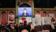Supporters of Shiite Hezbollah movement hold posters of slain Iranian Major General Qasem Soleimani as the movement's leader Hasan Nasrallah delivers a speech on a screen, in the Lebanese capital Beirut's southern suburbs on January 5, 2020.  AFP / ANWAR 