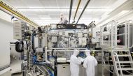 Employees are seen working on the final assembly of ASML's TWINSCAN NXE:3400B semiconductor lithography tool with its panels removed, in Veldhoven, Netherlands, in this picture taken April 4, 2019. Bart van Overbeeke Fotografie/ASML/Handout via Reuters