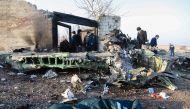 People stand near the wreckage after a Ukrainian plane carrying 176 passengers crashed near Imam Khomeini airport in Tehran on January 8, 2020. AFP / ISNA / ISNA / ROHHOLLAH VADATI