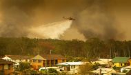 FILE PHOTO: An Air-crane water bombing helicopter drops water on a bushfire in Harrington, Australia, November 8, 2019. AAP Image / Shane Chalker via Reuters