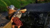 A woman carrying a bucket after collecting drinking water from a steam at Nongthymmai-Lumthangding village on the outskirts of Shillong in Meghalaya September 19, 2019. AFP / Diptendu Dutta 