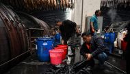 This photo taken on November 8, 2019 shows a worker handling a cow hide at the Boyin leather tannery in Shenqiu, in China's central Henan province.  AFP / Greg Baker