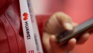 FILE PHOTO: An attendee wears a badge strip with the logo of Huawei and a sign for 5G at the World 5G Exhibition in Beijing, China November 22, 2019. REUTERS/Jason Lee