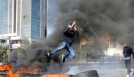 A protestor jumps over a burning barricade during a protest over economic hardship and lack of new government in Beirut, Lebanon January 14, 2020. Reuters/Mohamed Azakir
 