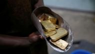 An employee holds gold bars before the refining process at African Gold Refinery in Entebbe, Uganda, October 4, 2018. Reuters/Baz Ratner