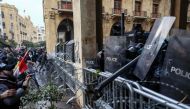 Lebanese security forces take cover behind riot shields during clashes with anti-government protesters in the central downtown district of the Lebanese capital near the parliament headquarters on January 18, 2020. / AFP / Anwar AMRO