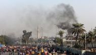  A view of clashes between Iraqi security forces (unseen) and anti-government protesters (foreground) as tuktuks (motorised rickshaws) are present on the scene to transport the injured, at Tayaran Square, east of Tahrir Square in the centre of the capital
