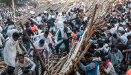 A crowd removes scaffoldings of a structure that collapsed, trapping and injuring dozens of people, during the celebration of Timkat, the Ethiopian Epiphany, in Gondar, Ethiopia, on January 20, 2020. AFP / Eduardo Soteras
 