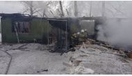 This handout picture released by the Russian Emergencies Ministry shows firefighters working at the site of a fire that broke out in a one-storey wooden shack in the Prichulymsky settlement in Russia's Tomsk region on January 21, 2020. 