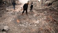 A Syrian man looks at a crater caused by a reported pro-regime bombardment in the village of Al-Jineh, in Aleppo's western countryside, on January 20, 2020. / AFP / Aaref WATAD