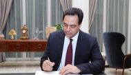 A handout picture provided by the Lebanese photo agency Dalati and Nohra on on January 21, 2020 shows Lebanon's new Prime Minister Hassan Diab signing official documents at the presidential palace in Baabda, east of the capital Beirut, as the new governme