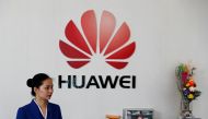 An employee stands next to the logo of Huawei in Shenzhen Guangdong province, China, March 29, 2019. Reuters / Tyrone Siu?
 