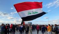 A demonstrator carries an Iraqi flag during ongoing anti-government protests in Nassiriya, Iraq January 22, 2020. REUTERS/Ahmed Dhahi 