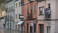 People looks at a flooded street from a balcony in Sarria de Ter on January 23, 2020, as storm Gloria batters Spanish eastern coast. AFP / Josep Lago
 