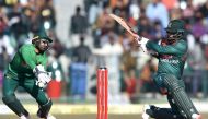 :Bangladesh's Tamim Iqbal (R) plays a shot as Pakistan's wicketkeeper Mohammad Rizwan tries to stop the ball during the first T20 international cricket match of a three-match series between Pakistan and Bangladesh at Gaddafi Cricket Stadium in Lahore on J