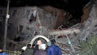 People stand outside a collapsed building after an earthquake in Elazig, Turkey, January 24, 2020. Ihlas News Agency via Reuters 

