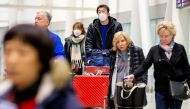 Travellers wear masks at Pearson airport arrivals, shortly after Toronto Public Health received notification of Canada's first presumptive confirmed case of coronavirus, in Toronto, Ontario, Canada January 25, 2020. REUTERS/Carlos Osorio