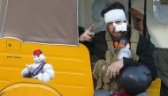 An injured Iraqi protester gestures the 