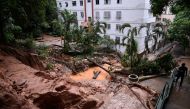 A local walks up stairs next to an area covered with mud and water after heavy rains at the Sao Pedro neighborhood, in Belo Horizonte, state of Minas Gerais, Brazil, on January 29, 2020. The death toll from days of intense storms and flooding in southeast