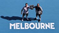 Rajeev Ram of the US and Britain's Joe Salisbury (L) pose with the winners' trophy after they beat Australia's Max Purcell and Australia's Luke Saville in their men's doubles final match on day fourteen of the Australian Open tennis tournament in Melbourn