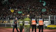 Moroccan security forces stand on guard as supporters of Raja Club Athletic chant slogans and wave their flags as they attend a Moroccan Botola football match between Raja and Mouloudia Oujda in Casablanca on January 22, 2020. AFP / Fadel Senna 
 