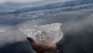 A small block of ice is displayed for a photo, close to Fournier Bay, Antarctica, February 3, 2020. Picture taken February 3, 2020. REUTERS/Ueslei Marcelino
