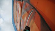 Brazilian artist Marcelo Eco works on a mural depicting indigenous people in protest against the construction of hydroelectric power plants in the Amazon rainforest in Rio de Janeiro, August 7, 2016. Reuters 