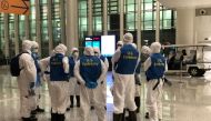 Staff from the US embassy assemble before inspecting a cargo plane, chartered by the US State Department to evacuate Americans and Canadians from China due to the outbreak of novel Coronavirus, at Wuhan Tianhe International Airport in Wuhan, China Februar