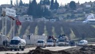 Vehicles carrying displaced Syrians pass by an internally-displaced persons (IDP) camp by Dayr Ballut near the Turkish border in the west of the northern province of Aleppo on February 15, 2020, as people flee advancing Syrian government forces in Idlib a