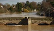 A man walks on the Old Bridge in Hereford, western England, on February 17, 2020, as the waters of the swollen River Wye fill the arches in the aftermath of Storm Dennis.  AFP / Oli Scarff
 