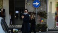 Reporters wearing protective surgical mask walk across Codogno, southeast of Milan, on February 22, 2020.   AFP / Miguel MEDINA