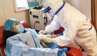 A person (L), who has recovered from the COVID-19 coronavirus infection, donates plasma in Zouping in China's eastern Shandong province on February 28, 2020, aimed at curing infected patients in severe and critical conditions./ AFP / STR