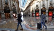 Tourists wearing protective face masks walk in Galleria Vittorio Emanuele II in the centre of Milan, on February 28, 2020, after COVID-19, the novel coronavirus, spread to Italy. AFP / Miguel Medina 