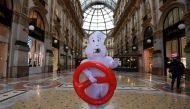 A man disguised in a ghost outfit walks around a near-deserted Galleria Vittorio Emanuele II luxury mall on February 29, 2020, in central Milan, northern Italy.  AFP / Miguel MEDINA