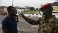 A soldier checks the body temperature of a visitor to the 68 Nigerian Army Reference Hospital at Yaba in Lagos, on February 28, 2020.  AFP / Pius Utomi Ekpei 
 