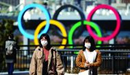 People wearing protective face masks, following an outbreak of the coronavirus, are seen in front of the Giant Olympic rings at the waterfront area at Odaiba Marine Park in Tokyo, Japan, February 27, 2020. Reuters/Athit Perawongmetha